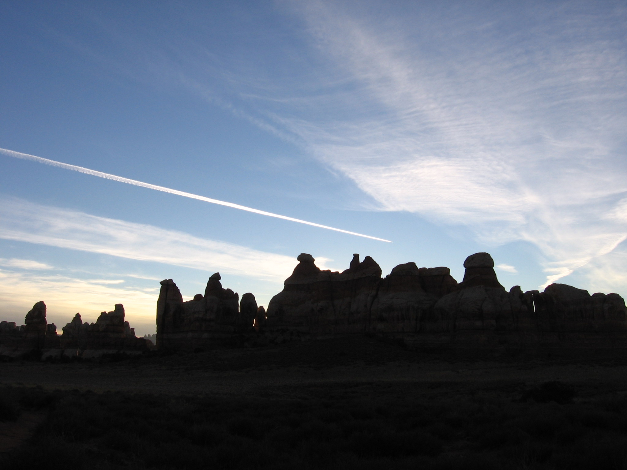 sunset behind contrails over rocks over chesler park 