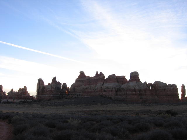 contrails over rocks over chesler park in front of sunset