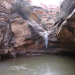 frozen pool and waterfall in elephant canyon below druid arch