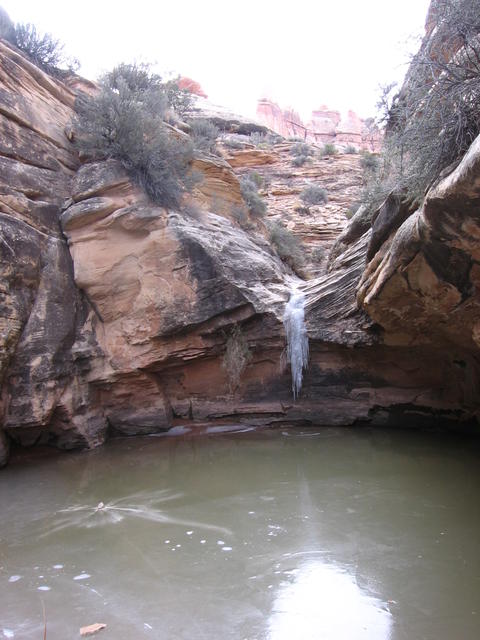 frozen pool and waterfall in elephant canyon below druid arch